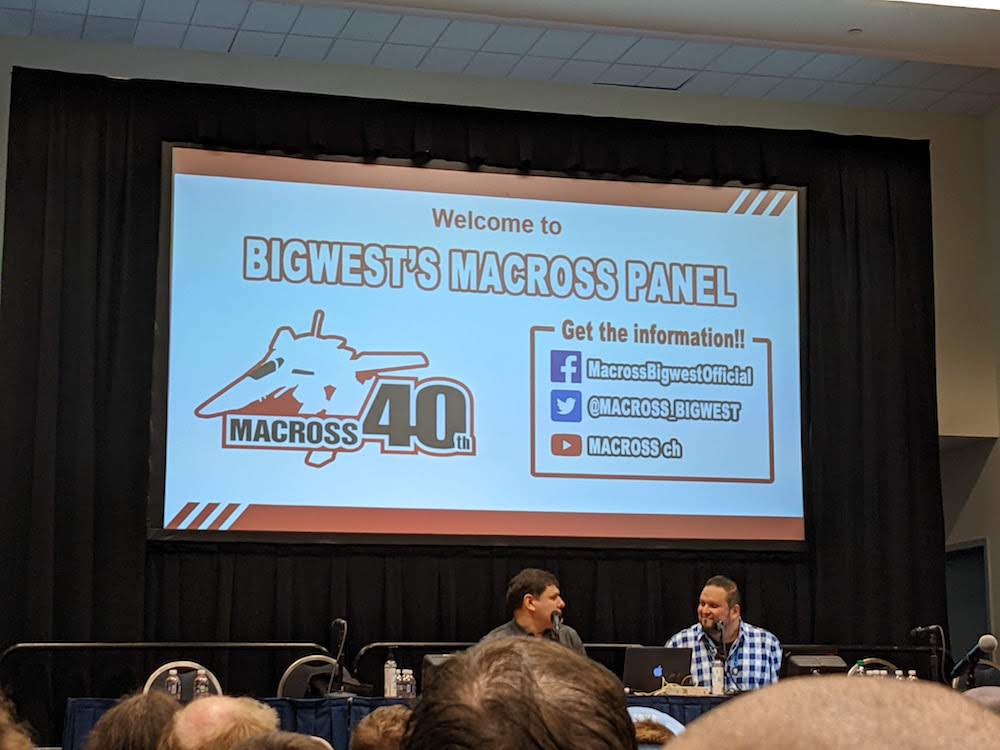A photo of the Macross Panel showing the introductory slide that says "Welcome to Bigwest's Macross Panel"