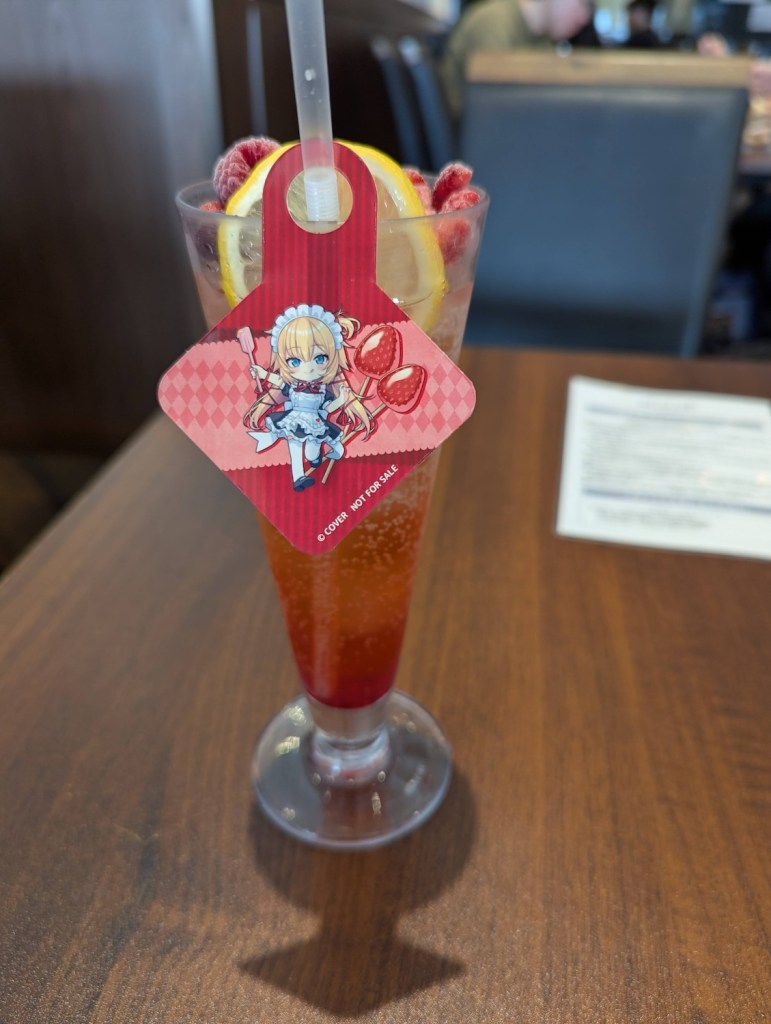 A Shirley Temple with a little decorative Haachama drawing, and fruits on top.